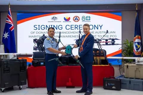 A Philippine Coast Guard officer and an Australian official at the signing ceremony for Australia's donation to the coast guard