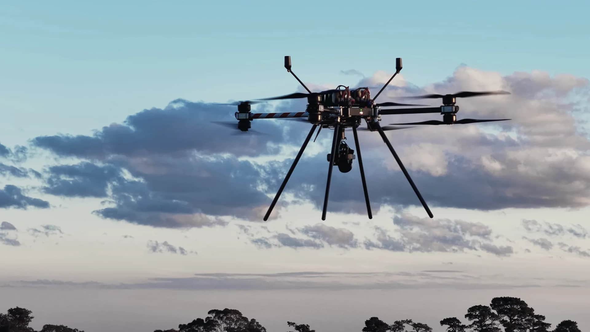 A Callisto 50 with its gimbal camera in flight against a blue sky and cloud