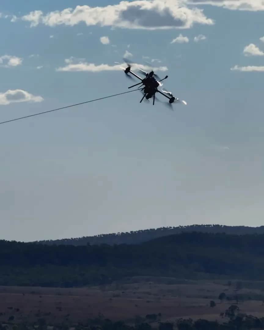 A Callisto pulling a pilot line across a valley, hills behind
