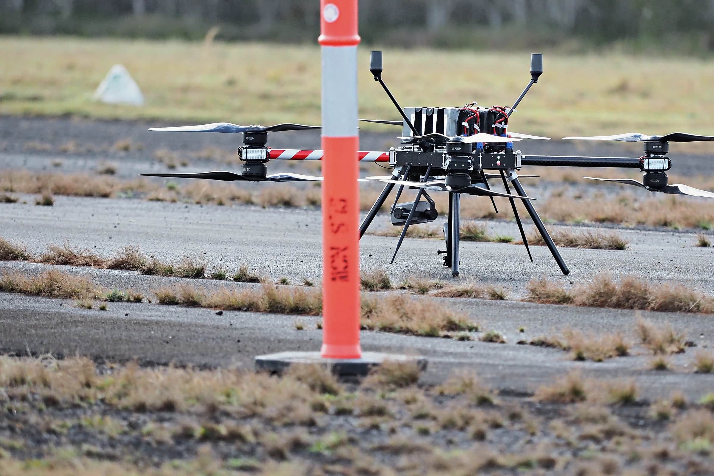 A Callisto on an airfield apron beside a marker post during a field day