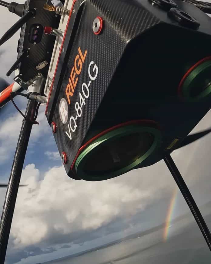 Looking up at the RIEGL VQ-840-G LiDAR beneath a Callisto in flight, cloud behind